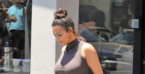 Kim Kardashian kobieco w szarej sukience 